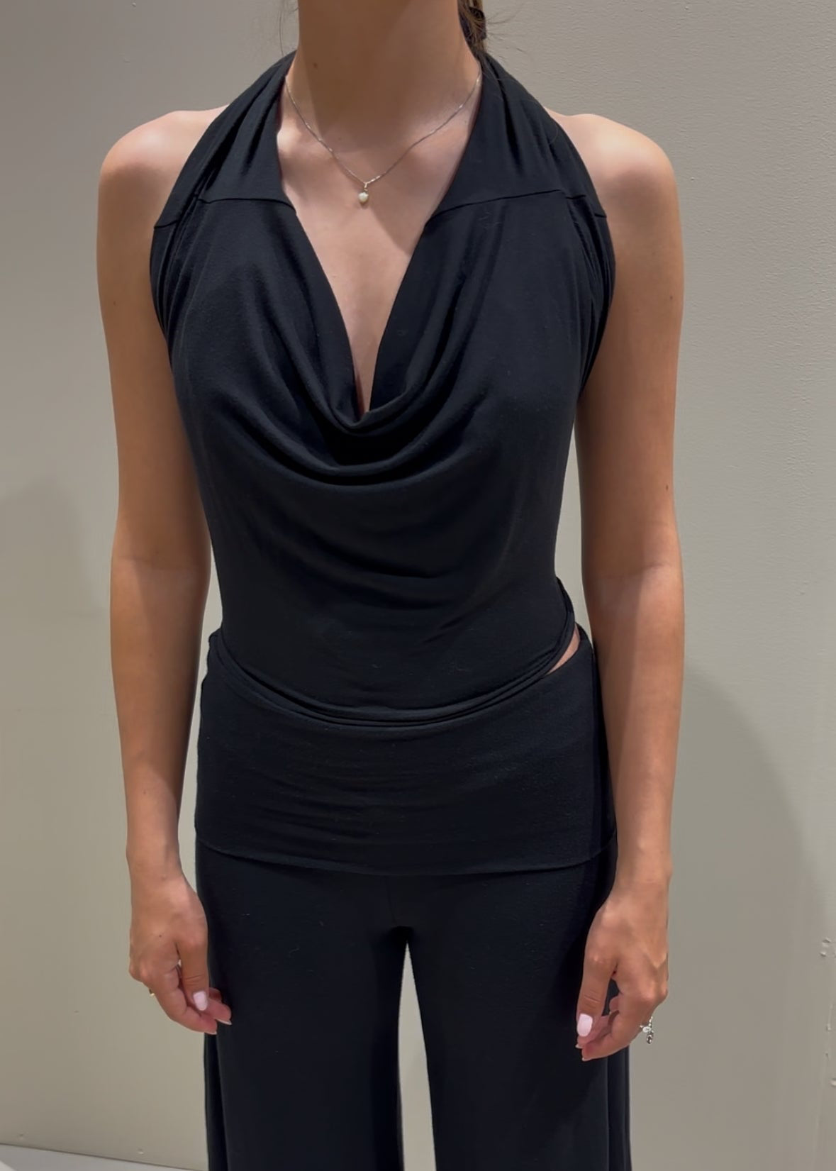 Black sleeveless top and wide-leg pants on a mannequin against a neutral background