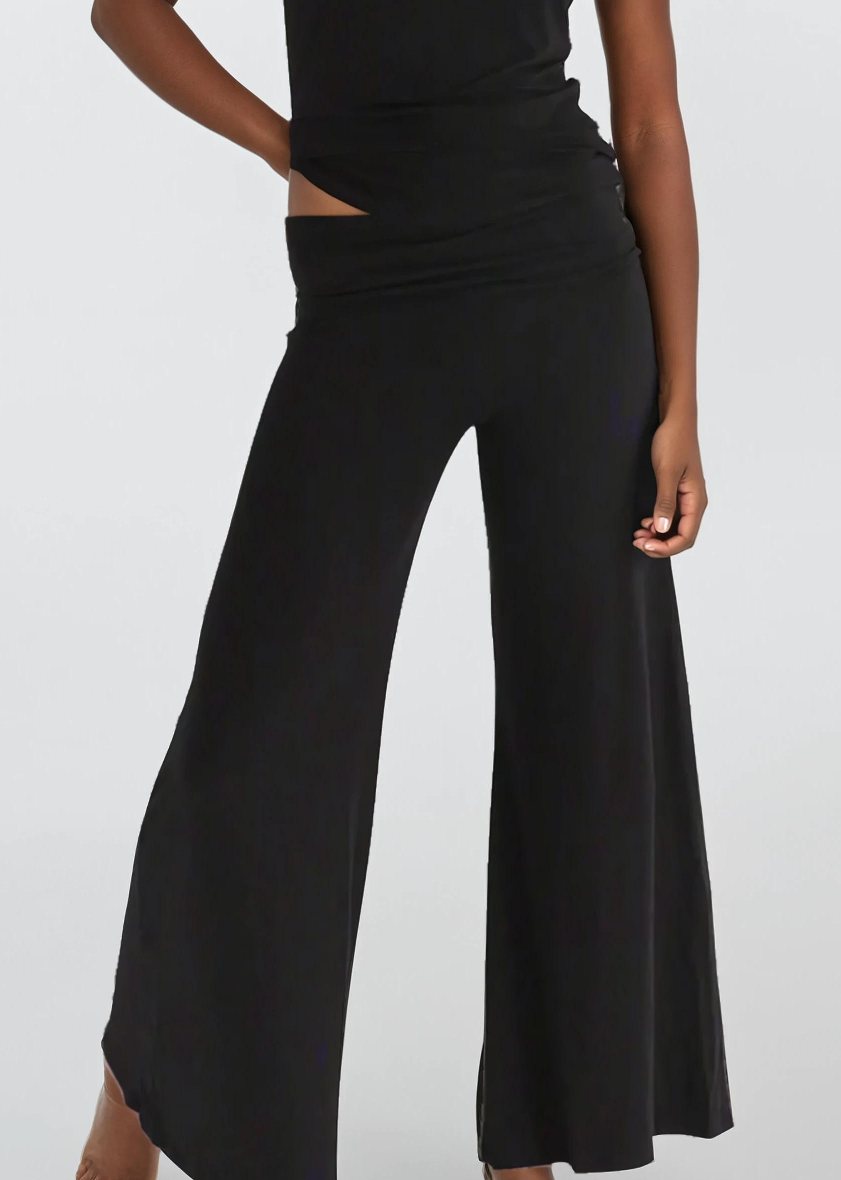 Woman wearing a black outfit with wide-leg pants on a white background