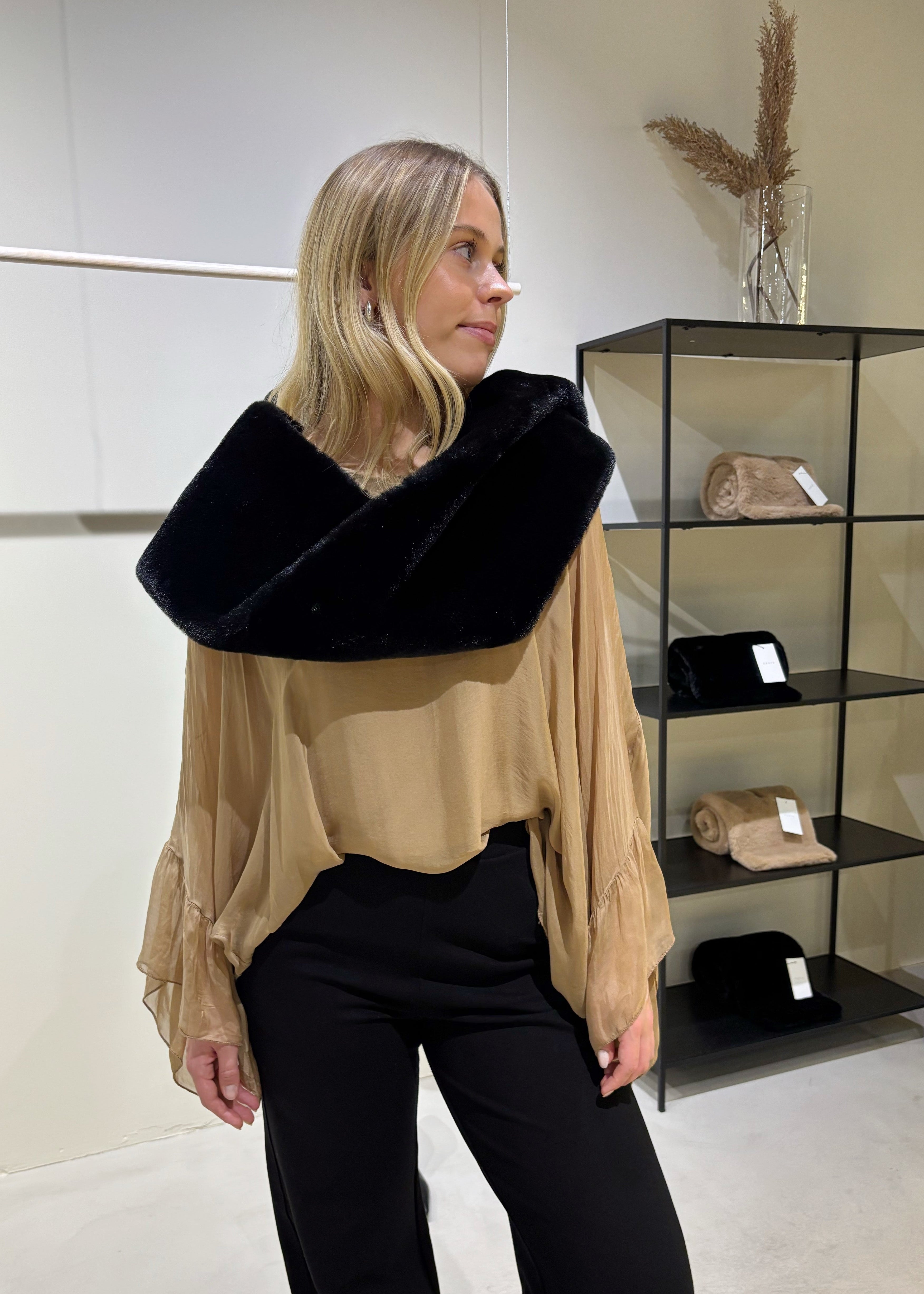 Woman wearing a black and beige outfit in a store setting