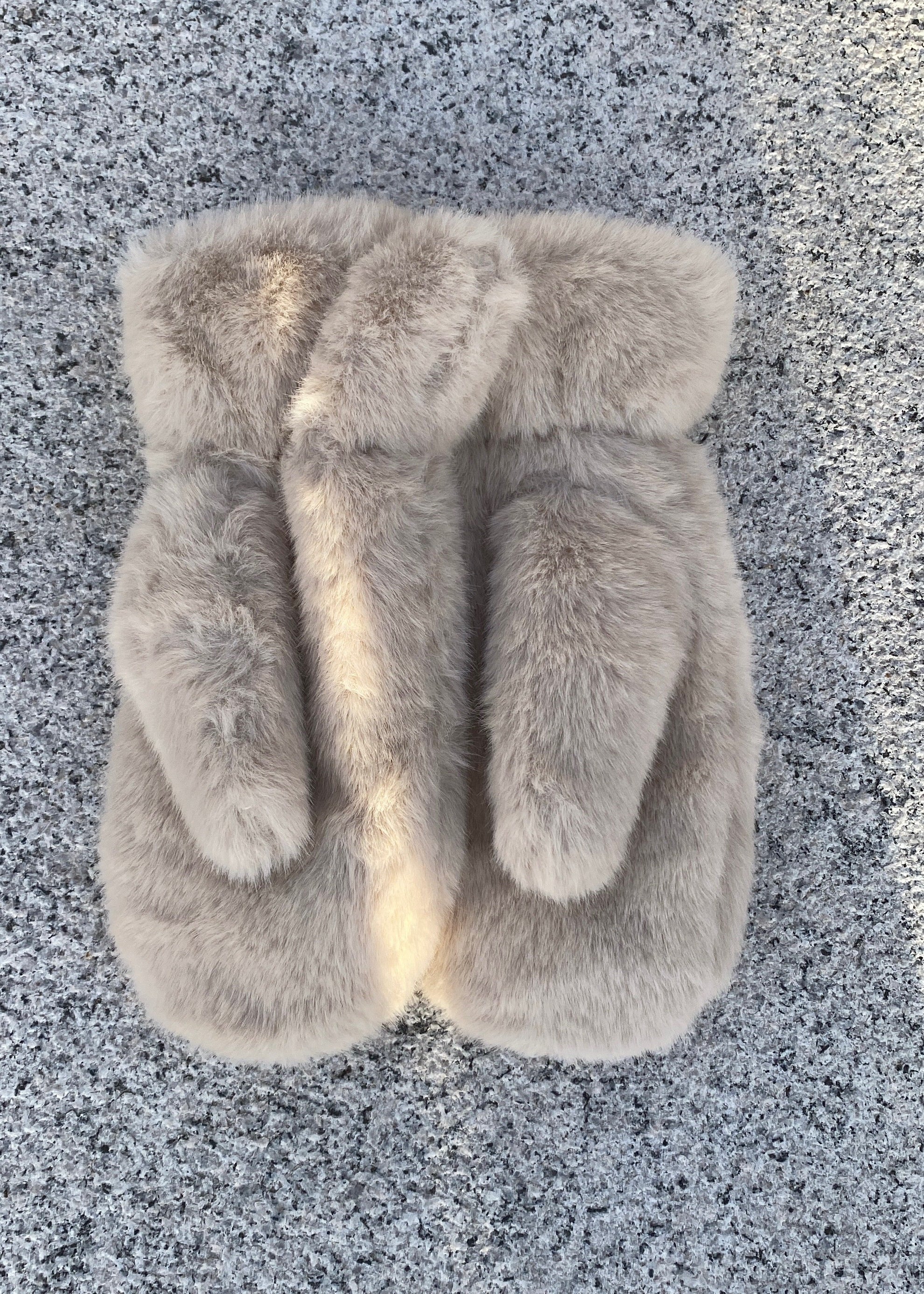 Pair of fluffy slippers on a textured gray surface