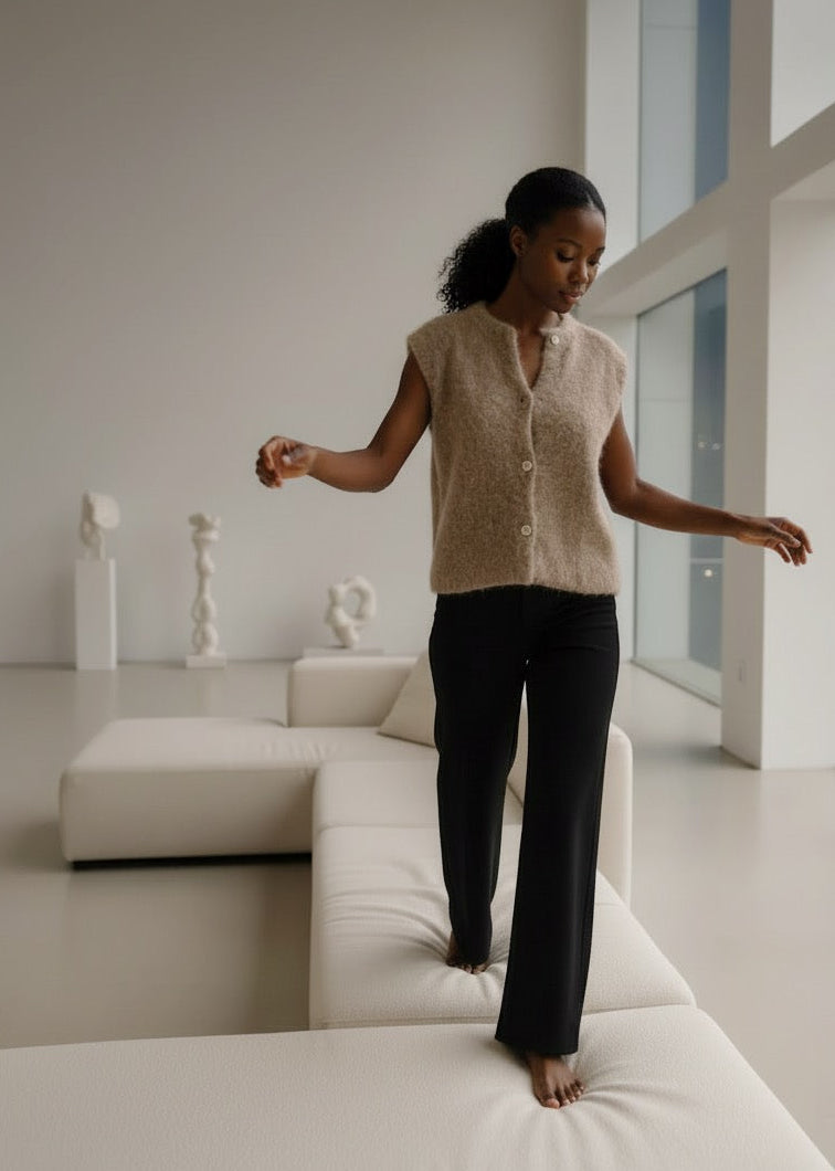 Woman standing on a white sofa in a modern living room.