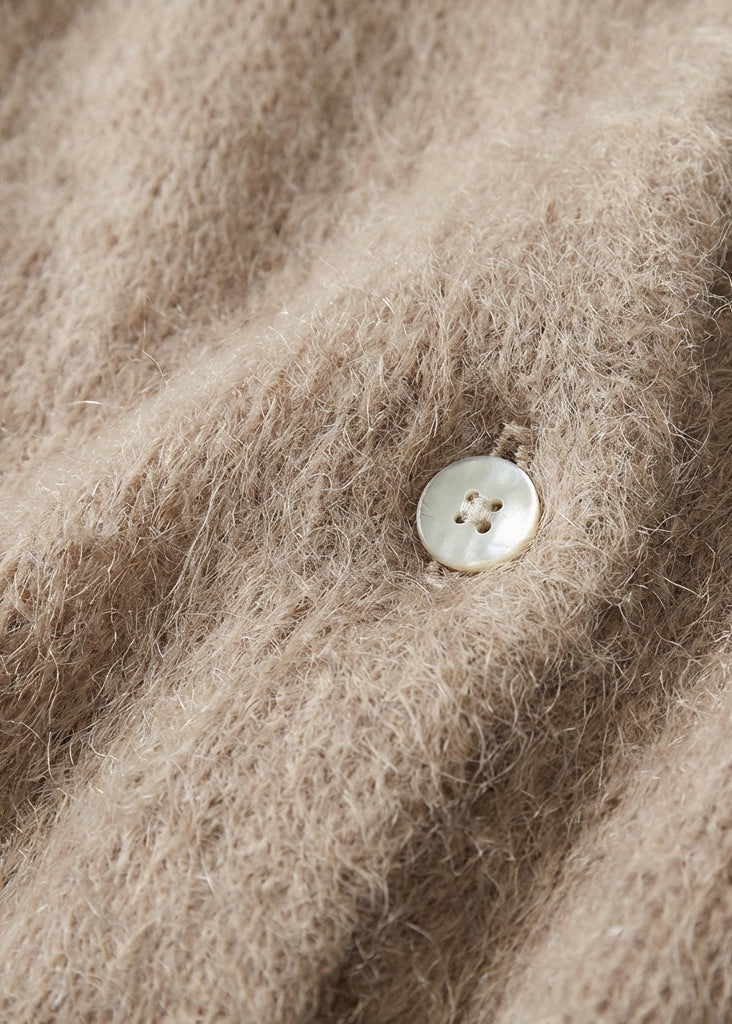 Close-up of a button on a textured beige fabric surface